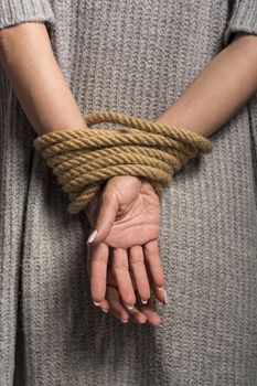 Womans hands on back tied with a rope, long nails