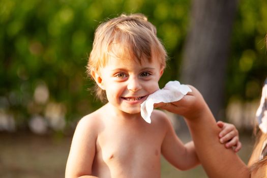 Hygiene - mom wiping the baby skin with wet wipes. Cleaning wipe, clean, outdoor