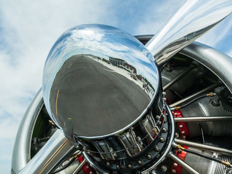 AT-6 Texan, known as the Harvard training plane engine with close up of reflection of runway and airfield in the nose of the propeller