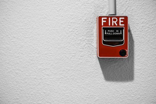 Fire alarm on white wall with copy space