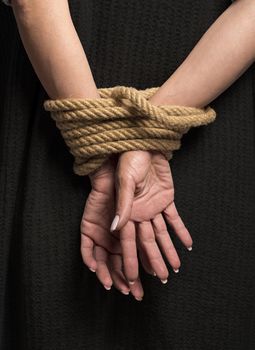 Womans hands on back tied with a rope, long nails