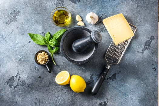 Pesto genovese sauce Ingredients italian recipe Parmesan cheese, basil leaves, pine nuts, olive oil, garlic and salt. Traditional Italian cuisine. on the stone table on gray concrete background Top view.