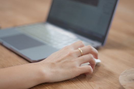 Woman working on computer in coffee shop, stock photo