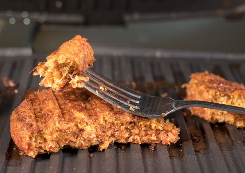 Close shot of the meat like plant-based patties for vegetarian beef burgers being grilled on hot griddle