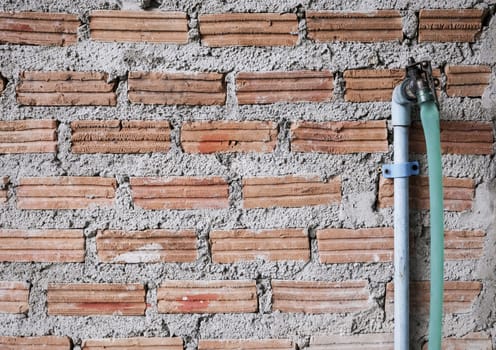 Faucet on brick wall with copy space