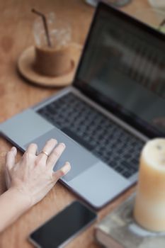 Woman working on computer in coffee shop, stock photo