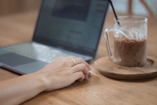 Woman working on computer in coffee shop, stock photo