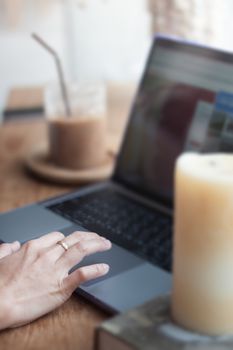 Woman working on computer in coffee shop, stock photo