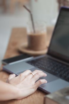 Woman working on computer in coffee shop, stock photo