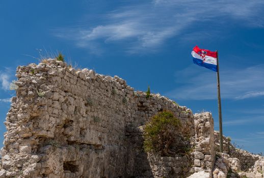Croatian flag flies above ruins of old Venetian fort above the coastal town of Novigrad in Croatia