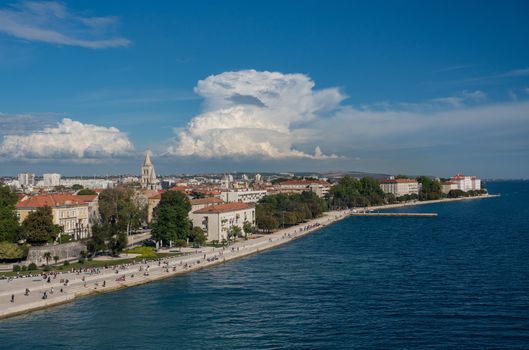 Tourists on the steps of Sea Organ along the promenande by the port of Zadar in Croatia