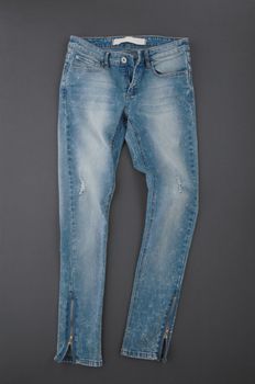 fashionable denim pants on grey background, top view