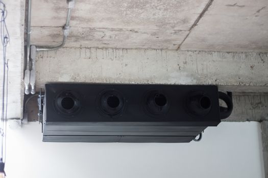 Black air conditioner on ceiling concrete, stock photo