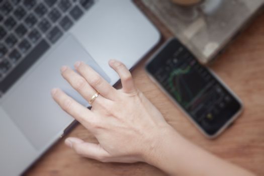 Woman working on computer in coffee shop, stock photo