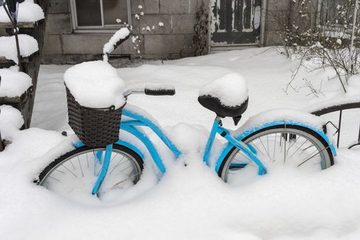 Blue bike covered in snow after snow storm in Montreal