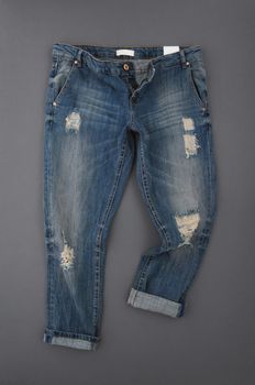 fashionable denim pants on grey background, top view