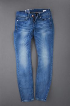 fashionable denim pants on grey background, top view