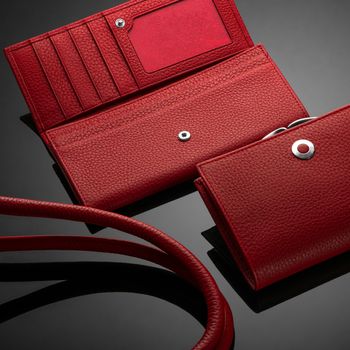 Fashionable red leather women's wallet on a dark background