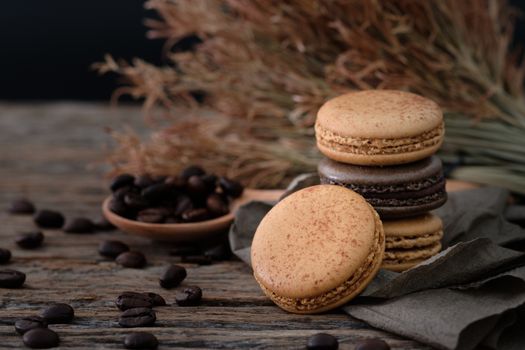 Chocolate and coffee macaroons  on wooden background in low light, AF point selection, copy space for write.
