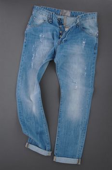 fashionable denim pants on grey background, top view