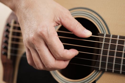 Close up woman's hands playing acoustic guitar.