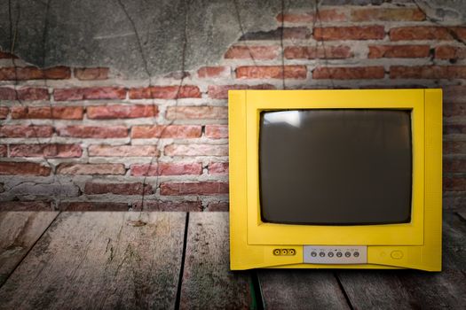 Retro old television from 80s on brick background with shadow.