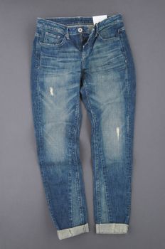 fashionable denim pants on grey background, top view