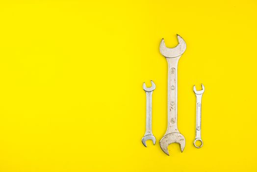 Spanner key on yellow background. Screw driver set. Wrench spanners. Background for your text and design.