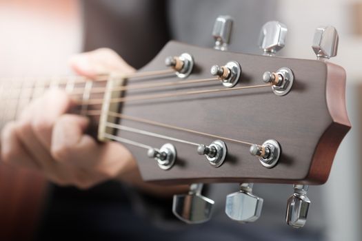 Close up woman's hands playing acoustic guitar.