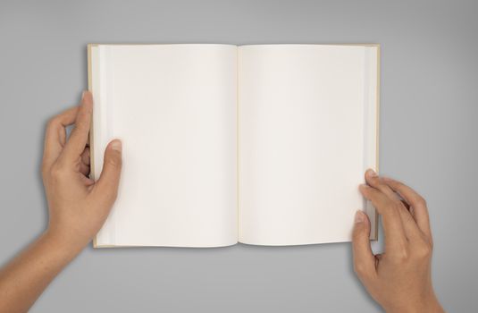 Top view- two hands hold a empty book spread.