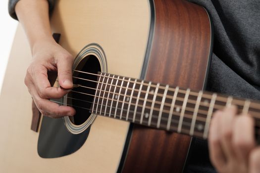 Close up woman's hands playing acoustic guitar.