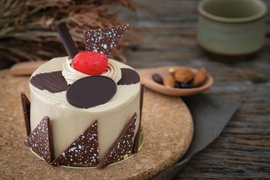 Vanilla cake with cherries on wooden background in low light, AF point selection, copy space for write.