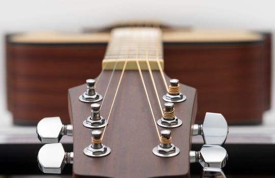 Close up of an acoustic guitar headstock on white background.