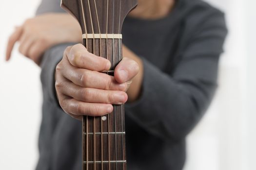 Close up woman's hands playing acoustic guitar.