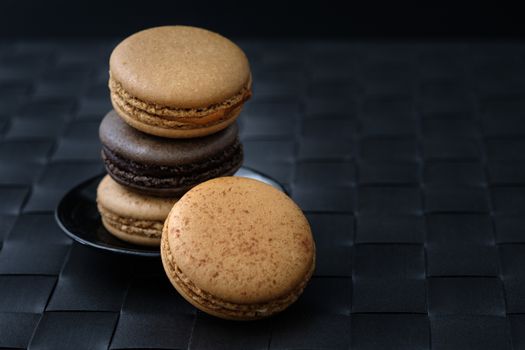 Chocolate and coffee macaroons  on wooden background in low light, AF point selection, copy space for write.