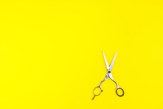 Stylish Professional Barber Scissors on yellow background. Hairdresser salon concept, Hairdressing Set. Haircut accessories. Copy space image, flat lay