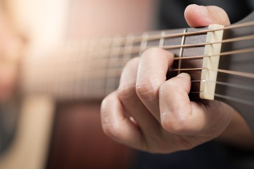 Close up woman's hands playing acoustic guitar.