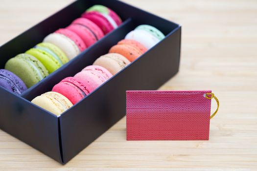 Sweet and colorful macaroons cookies in the black box on wooden background with blank space,selective focus, Dessert.