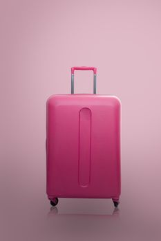 Traveler pink suitcase or cabin size luggage on pink background with shadow, Journey and travel concept.