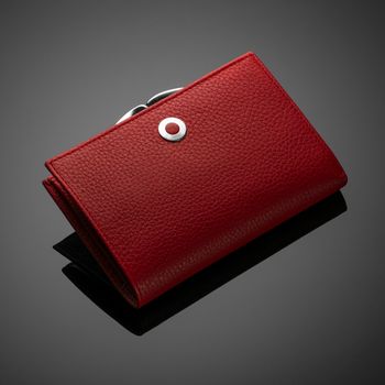Fashionable red leather women's wallet on a dark background