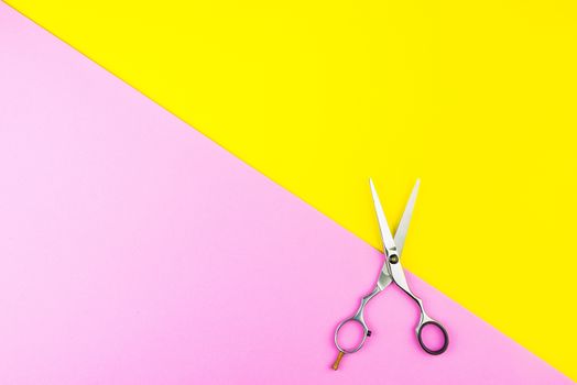 Stylish Professional Barber Scissors on yellow and pink background. Hairdresser salon concept, Hairdressing Set. Haircut accessories. Copy space image, flat lay