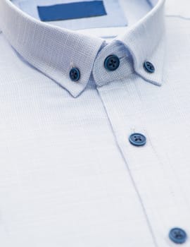 blue shirt with a focus on the collar and button, close-up