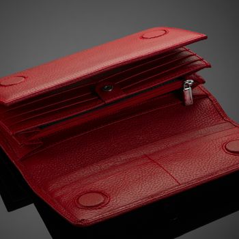 Fashionable red leather women's wallet on a dark background