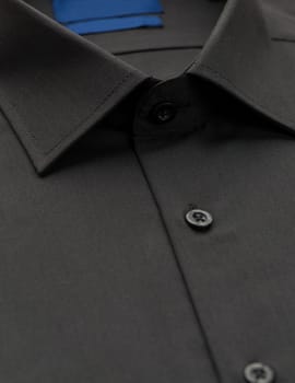 black shirt with a focus on the collar and button, close-up