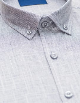 grey shirt with a focus on the collar and button, close-up