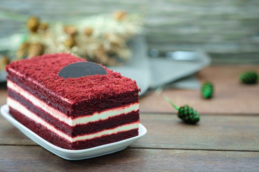 Red velvet cake and white cream on wooden table, close up, space to write.