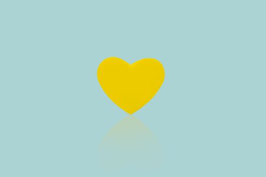 Yellow heart isolated on blue background.