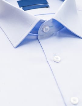 light blue shirt with a focus on the collar and button, close-up