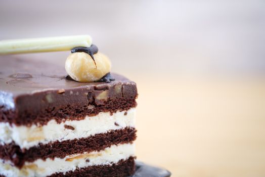 Chocolate cake with white cream on wooden table, close up, space to write, Select a focus, blurred