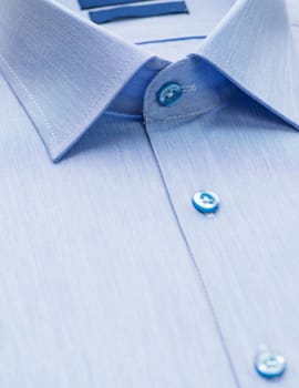 light blue shirt with a focus on the collar and button, close-up